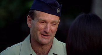 Movie still from “Good Morning, Vietnam” (1987), directed by Barry Levinson – A person wearing a hat; Close Up shot, Over the shoulder angle