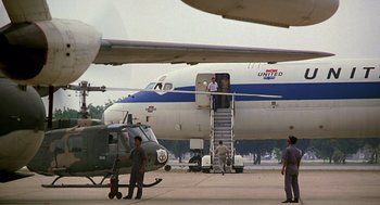 Movie still from “Good Morning, Vietnam” (1987), directed by Barry Levinson – A united airlines plane sitting on top of an airport runway; Extreme Wide shot, Low angle