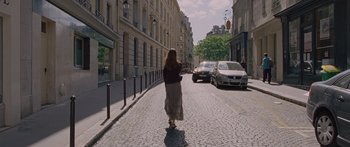 Movie still from “To the Wonder” (2012), directed by Terrence Malick – A woman is walking down the street in the city; Wide shot, Over the shoulder angle