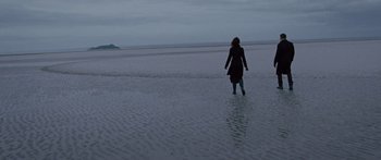 Movie still from “To the Wonder” (2012), directed by Terrence Malick – A woman is walking on the beach at dusk; Extreme Wide shot, High angle