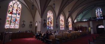 Movie still from “To the Wonder” (2012), directed by Terrence Malick – People sitting on pedestals in a church with stained - glass windows; Extreme Wide shot, Low angle