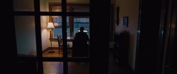 Movie still from “To the Wonder” (2012), directed by Terrence Malick – A person sitting at a table looking out of a window; Wide shot, High angle