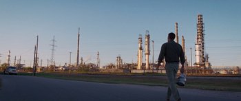Movie still from “To the Wonder” (2012), directed by Terrence Malick – A man walking down a street near a factory; Extreme Wide shot, Low angle
