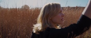 Movie still from “To the Wonder” (2012), directed by Terrence Malick – A woman with long blonde hair standing next to a field; Close Up shot, Low angle