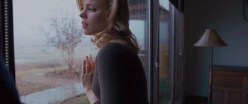 Movie still from “To the Wonder” (2012), directed by Terrence Malick – A woman standing in front of a window with her hands folded in prayer; Medium shot, Low angle