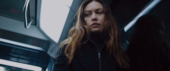 Movie still from “To the Wonder” (2012), directed by Terrence Malick – A woman with long brown hair wearing a black jacket; Close Up shot, Low angle