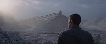 Movie still from “To the Wonder” (2012), directed by Terrence Malick – A man standing in front of a conveyor belt; Extreme Wide shot, Low angle