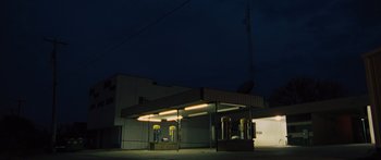 Movie still from “To the Wonder” (2012), directed by Terrence Malick – A gas station at night lit by street lights; Extreme Wide shot, Low angle