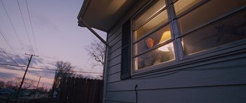 Movie still from “To the Wonder” (2012), directed by Terrence Malick – A person looking out of a window at dusk; Wide shot, Low angle