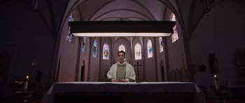 Movie still from “To the Wonder” (2012), directed by Terrence Malick – A man standing in front of a cross in a church; Wide shot, Low angle