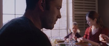 Movie still from “To the Wonder” (2012), directed by Terrence Malick – A person sitting at a table with a plate of food; Close Up shot, Over the shoulder angle