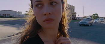 Movie still from “To the Wonder” (2012), directed by Terrence Malick – A woman's face with a building in the background; Close Up shot, High angle