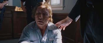 Movie still from “To the Wonder” (2012), directed by Terrence Malick – A man with long blonde hair is sitting in a room; Close Up shot, Over the shoulder angle