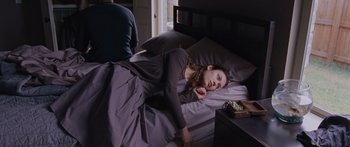 Movie still from “To the Wonder” (2012), directed by Terrence Malick – A woman laying in a bed next to a man; Medium shot, High angle