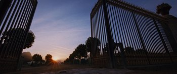 Movie still from “To the Wonder” (2012), directed by Terrence Malick – The sun is setting behind a metal fence; Extreme Wide shot, Low angle