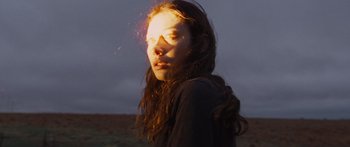 Movie still from “To the Wonder” (2012), directed by Terrence Malick – A woman with long hair is standing in a field; Close Up shot, Low angle