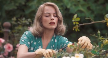 Movie still from “Goodbye Christopher Robin” (2017), directed by Simon Curtis – A woman in a green dress holding a pair of gardening gloves; Close Up shot, Over the shoulder angle
