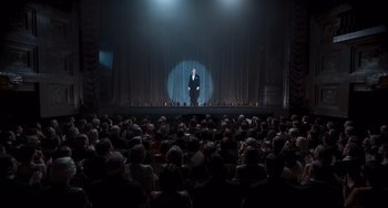 Movie still from “Goodbye Christopher Robin” (2017), directed by Simon Curtis – A man standing on a stage in front of an audience; Extreme Wide shot, High angle