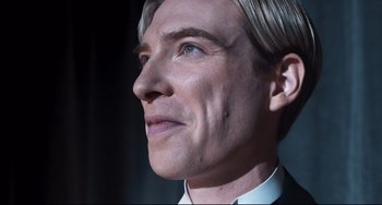 Movie still from “Goodbye Christopher Robin” (2017), directed by Simon Curtis – A man's face in a suit and tie; Close Up shot, Low angle