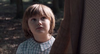 Movie still from “Goodbye Christopher Robin” (2017), directed by Simon Curtis – A young boy is looking up at the sky; Close Up shot, Over the shoulder angle