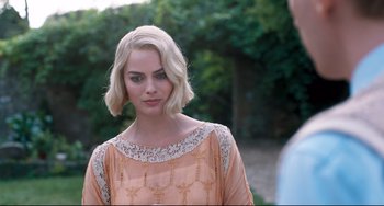 Movie still from “Goodbye Christopher Robin” (2017), directed by Simon Curtis – A woman with blonde hair wearing an orange dress; Close Up shot, Over the shoulder angle