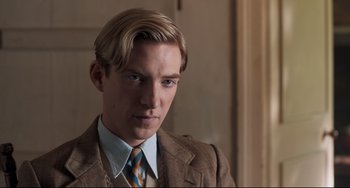 Movie still from “Goodbye Christopher Robin” (2017), directed by Simon Curtis – A man in a suit and tie looking at the camera; Close Up shot, Over the shoulder angle