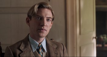Movie still from “Goodbye Christopher Robin” (2017), directed by Simon Curtis – A man in a suit and tie standing in front of a door; Close Up shot, Over the shoulder angle