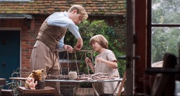 Movie still from “Goodbye Christopher Robin” (2017), directed by Simon Curtis – A man and a boy working together on a table; Medium shot, Over the shoulder angle
