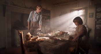 Movie still from “Goodbye Christopher Robin” (2017), directed by Simon Curtis – A woman and two children sitting at a dinner table; Medium shot, Low angle