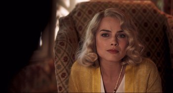 Movie still from “Goodbye Christopher Robin” (2017), directed by Simon Curtis – A woman sitting in a chair wearing a yellow jacket; Close Up shot, Over the shoulder angle