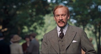 Movie still from “Goodbye Christopher Robin” (2017), directed by Simon Curtis – An older man in a suit and a tie; Medium shot, Low angle