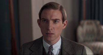 Movie still from “Goodbye Christopher Robin” (2017), directed by Simon Curtis – A person wearing a suit and tie; Close Up shot, Low angle