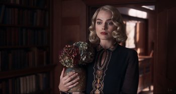 Movie still from “Goodbye Christopher Robin” (2017), directed by Simon Curtis – A beautiful blonde woman holding a vase of flowers; Medium shot, Over the shoulder angle