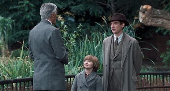 Movie still from “Goodbye Christopher Robin” (2017), directed by Simon Curtis – Two men and a boy wearing suits and hats; Medium shot, Over the shoulder angle