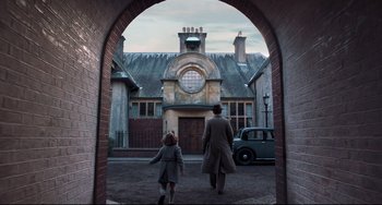 Movie still from “Goodbye Christopher Robin” (2017), directed by Simon Curtis – A man and a little girl walking through an archway; Wide shot, Low angle