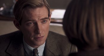 Movie still from “Goodbye Christopher Robin” (2017), directed by Simon Curtis – A person wearing a suit and tie; Close Up shot, Over the shoulder angle