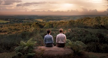 Movie still from “Goodbye Christopher Robin” (2017), directed by Simon Curtis – Two men sitting on a rock looking at the sky; Wide shot, High angle