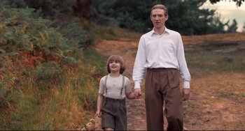 Movie still from “Goodbye Christopher Robin” (2017), directed by Simon Curtis – A man and a boy walking down a dirt road; Medium shot, Low angle