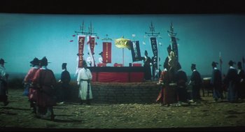 Movie still from “Goodbye, Dragon Inn” (2003), directed by Tsai Ming-liang – A group of people standing on top of a stage; Extreme Wide shot, Low angle