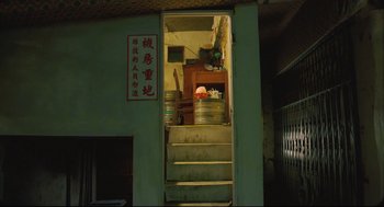 Movie still from “Goodbye, Dragon Inn” (2003), directed by Tsai Ming-liang – A room that has stairs leading up to it; Wide shot, Low angle