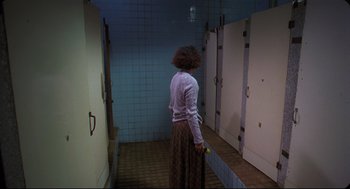 Movie still from “Goodbye, Dragon Inn” (2003), directed by Tsai Ming-liang – A woman with a cane standing in a bathroom; Wide shot, High angle