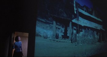 Movie still from “Goodbye, Dragon Inn” (2003), directed by Tsai Ming-liang – A projector screen showing an image of an old building; Wide shot, Low angle