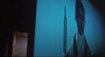 Movie still from “Goodbye, Dragon Inn” (2003), directed by Tsai Ming-liang – A man's face with a pen in front of him; Extreme Close Up shot, Low angle