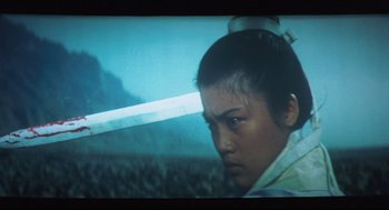 Movie still from “Goodbye, Dragon Inn” (2003), directed by Tsai Ming-liang – A woman with a sword in her hands; Medium shot, Low angle