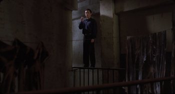 Movie still from “Goodbye, Dragon Inn” (2003), directed by Tsai Ming-liang – A man standing on top of a staircase; Wide shot, Low angle