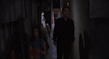 Movie still from “Goodbye, Dragon Inn” (2003), directed by Tsai Ming-liang – A man and a woman walking down a dark hallway; Medium shot, High angle