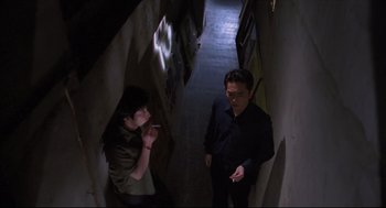Movie still from “Goodbye, Dragon Inn” (2003), directed by Tsai Ming-liang – A man and a woman standing next to each other in an alley; Medium shot, High angle