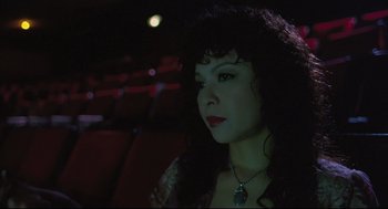 Movie still from “Goodbye, Dragon Inn” (2003), directed by Tsai Ming-liang – A person with long hair wearing a necklace; Close Up shot, High angle