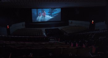 Movie still from “Goodbye, Dragon Inn” (2003), directed by Tsai Ming-liang – A movie screen in the middle of an empty auditorium; Extreme Wide shot, High angle