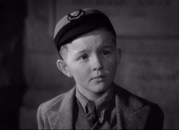Movie still from “Goodbye, Mr. Chips” (1939), directed by Sam Wood – A young boy wearing a hat and a suit; Close Up shot, High angle